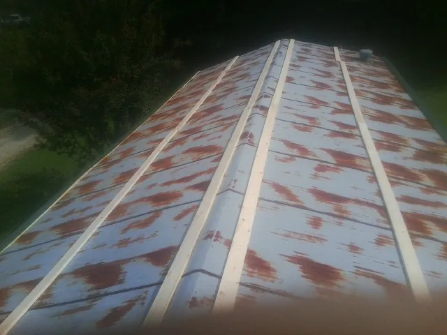 Rusted metal roof panels with new wood purlins before replacement — Storm Damage Roof Repair in Sperry by Roofing Brothers