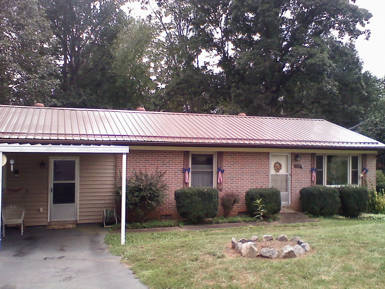 Bronze metal roof and carport on a brick ranch home — Roof Repair work by our crew in Sperry
